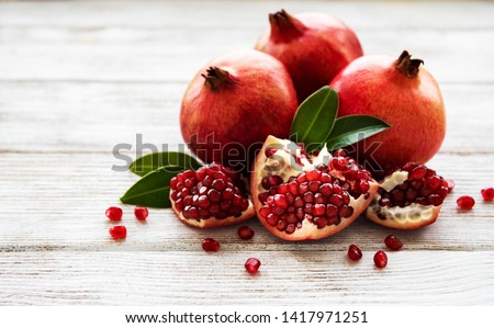 Ripe pomegranate fruits on  wooden vintage background Royalty-Free Stock Photo #1417971251