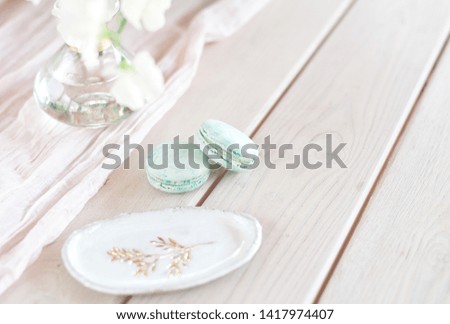 Sweet french macaroons on wood flat lay copyspace. Top voew on set of three purple macaroons on wooden board, lying diagonally on wooden table, void