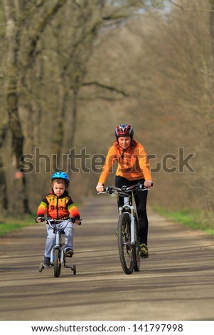 Mother and child riding bikes together during springtime