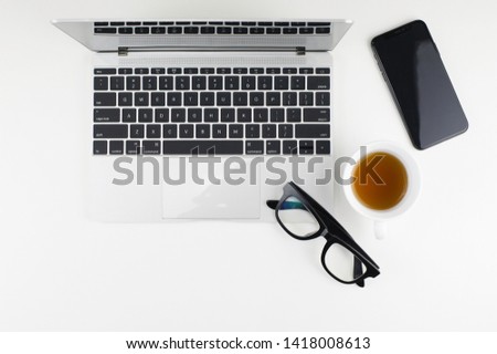 White desk office with laptop, smartphone and other supplies with cup of coffee. Top view with copy space for input the text.