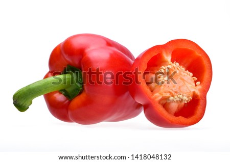 The fruit of a ripe red Bulgarian pepper with a green handle and half a pepper with white seeds on a neutral white background