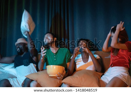 Group of friend sitting on sofa for watching television together, feeling  upset for lose game emotional in the night light environment background at home