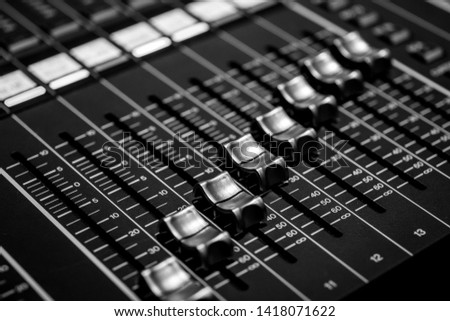 Closeup of Professional Audio Digital Mixing Sound Console. Silver White Faders and black control Console
