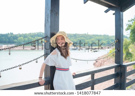 Single girl wearing a white student skirt looks at the love lock on the lover bridge and waits for her love