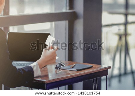 blur photo,The girl sat by the window of the house in the morning and was paying with a credit card to shopping via her tablet and enjoyed online shopping. Convenience concept with Online shopping