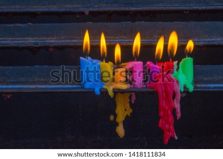 a shot of multi colored lit candles