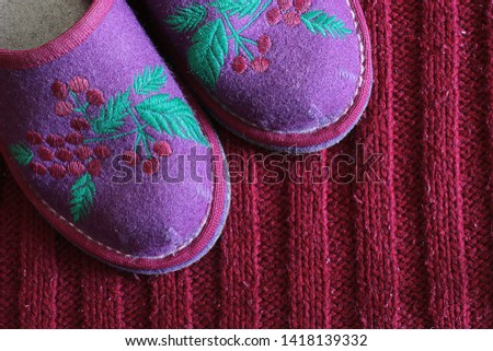 homemade pink grandma's slippers on a free and background, a place for an inscription on the background near bright comfortable shoes
