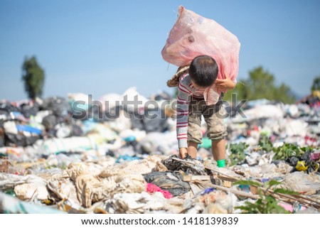 Poor boy collecting garbage in his sack to earn his livelihood, The concept of poor children and poverty Royalty-Free Stock Photo #1418139839