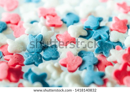 Multicolored sweet candy for sprinkling confectionery, ice cream and donuts. Edible children's toys and cookies in the form of animals,  rabbits. Background image, wallpaper.