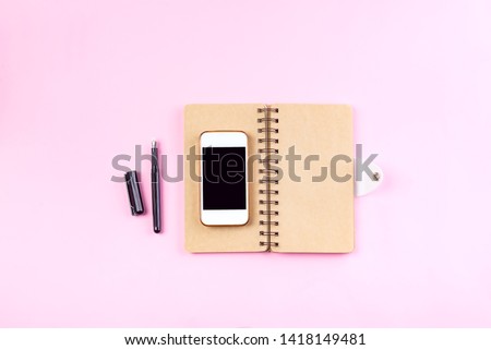 Notebooks craft, pen and smart phone on a pastel pink background . Mockup concept