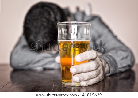 Black and white image of a sleeping drunk man (only his beer is in color) Royalty-Free Stock Photo #141815629