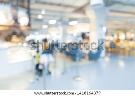 Blurred bix box store supercenter with customers shopping for home goods.