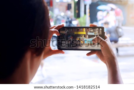 Selective focus of an asian woman take a landscape photo of Taipei, Taiwan in a morning by her cellphone