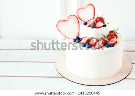 White cake with berries for wedding, birthday, celebration. Place for text.