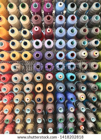 Many threads on a metal wall in a sewing workshop 