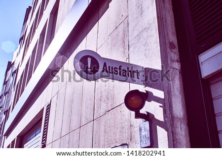 Garage of an office building with holding the sign and gate with gate and sign in german Ausfahrt in english exit