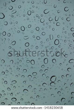 close-up picture of raindrops on windscreen on rainy day. cloudy sky. Droplets.