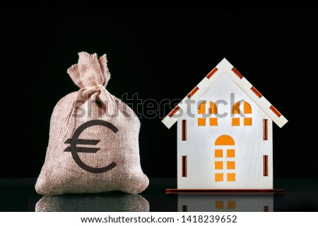 Mortgage concept. A bag with money with sign euro and house.  Concept of real estate acquisition and investment.