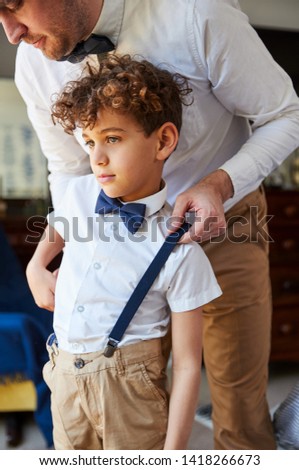Father And Son Wearing Matching Outfits Getting Ready For Wedding At Home Royalty-Free Stock Photo #1418266673