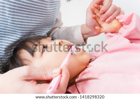 Mother brushing a child's teeth