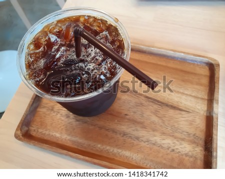 Americano ice coffee on the wood tray,close up picture.