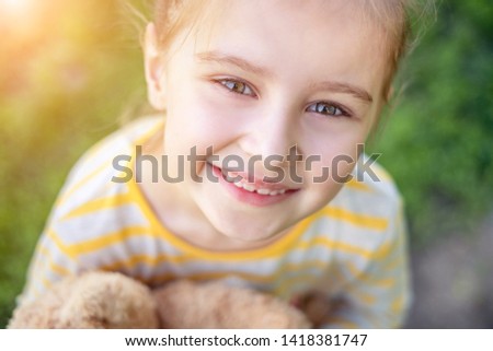 Portrait of cute smiling little child girl with at the park in summer