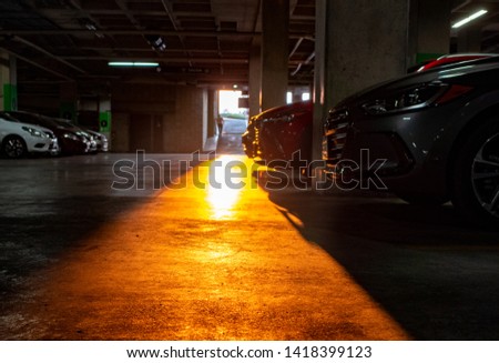 underground parking lot with early lights of sun entering by the main entrance