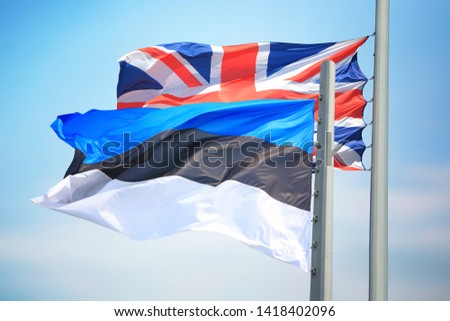 The Estonian and British flags against the background of the blue sky