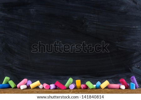 Black old empty chalkboard for copy space with colorful pieces of chalk