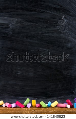 Black old empty chalkboard for copy space with colorful pieces of chalk
