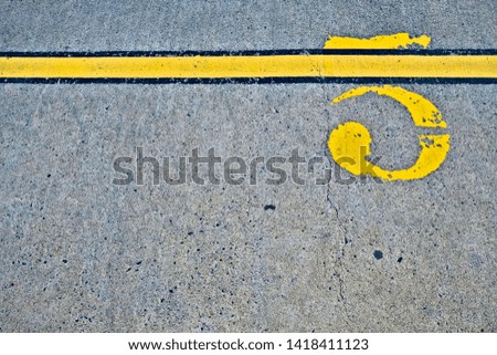 Figure 5 / five, yellow paint on grungy concrete pavement.