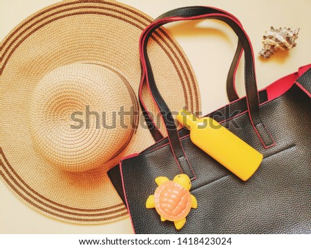Sun hat, handbag, sunscreen bottle, rubber turtle toy and seashell. Flat lay composition travel photo. Top view beach stuff