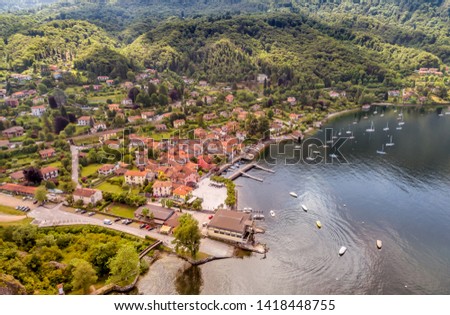 Aerial drone view of the village and the small harbor of Castelveccana, located on the shore of Lake Maggiore in the province of Varese, Lombardy, Italy