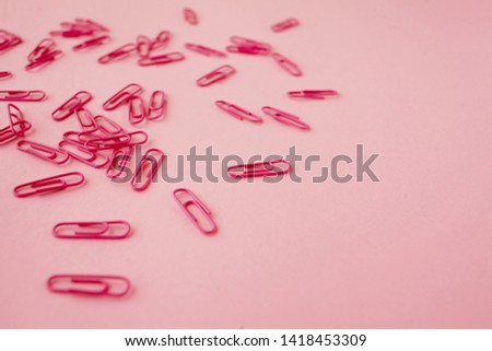 Scattered pink paper clips. Pink background. Flatlay. Copy space