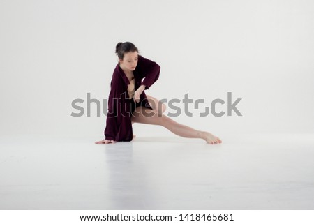 girl dancer on a white background with a place for the text. In a loose shirt. Orginal dance poses of modern dance
