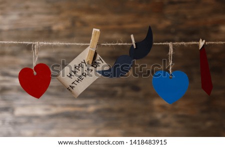 Handmade retro heart hanging over wooden background with happy father's day inscription