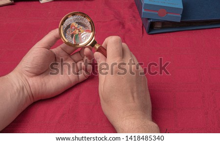 A close up of a coin with a magnifier. Picture of the monkey