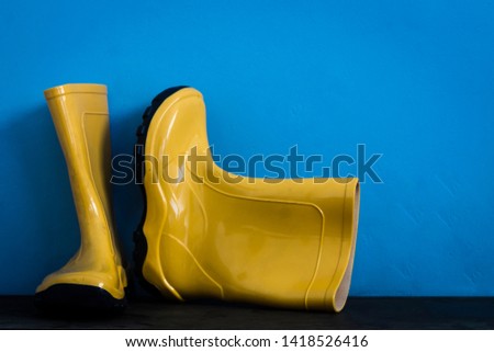 Yellow boots on blue wall