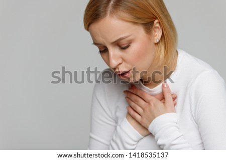 Breathing, respiratory problem, asthma attack, pressure, chest pain concept. Studio portrait of exhausted or tired female having rest after a hard day, isolated on grey background.  Royalty-Free Stock Photo #1418535137