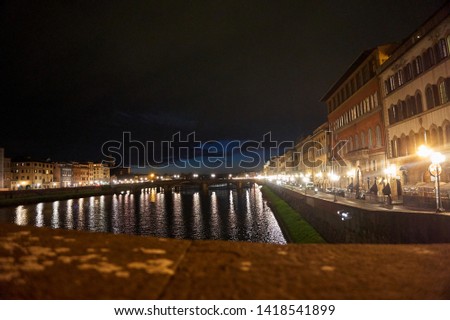 Ponte Santa Trinita bridge over the Arno River at night. Scenic view of the illuminated city of Florence, Italy at night.
