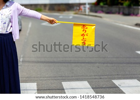 Young mother is holding stop sign.(Japanese translation: THANK YOU)