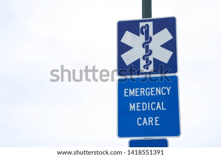Hospital symbol and "Emergency Medical Care" road sign, with space for text on the left