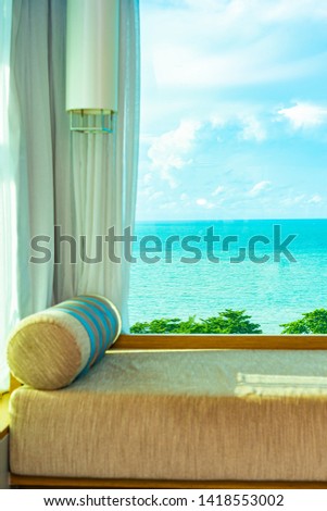 Beautiful comfortable pillow on sofa with sea ocean white cloud on blue sky view for leisure relax in vacation