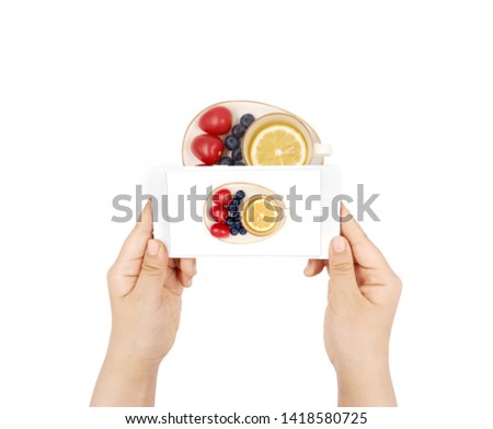                   
Female hand holding mobile phone Take a picture of afternoon tea on a white background 
             