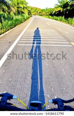The shadow of people riding on the natural road