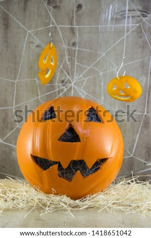 Jack lantern for Halloween of a basketball on a wooden background with spider webs.