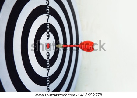 Red dart on board right direction hit target goal. Competition game to win focus on achievement with smart thinking planning accurate strategy. Outstanding perfect performance with concentrate concept