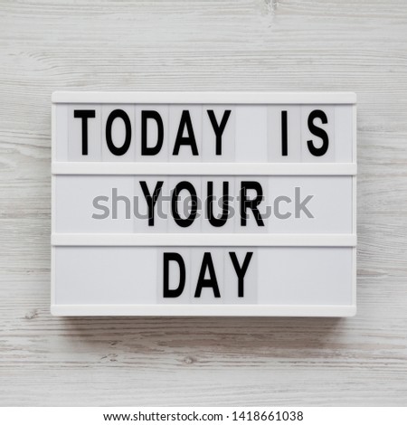 Light box with 'Today is your day' words on a white wooden background, top view. Flat lay, overhead, from above. Closeup.