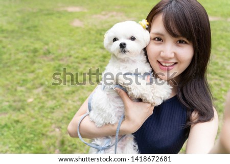 young asian woman and maltese in park