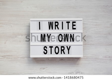 'I write my own story' words on a modern board on a white wooden surface, top view. From above, overhead, flat lay. 